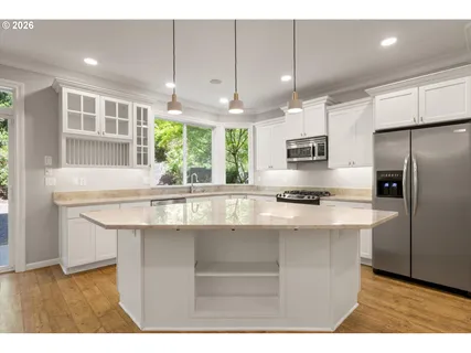 a kitchen with kitchen island a sink stainless steel appliances and cabinets
