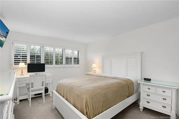 a bedroom with a bed and large window