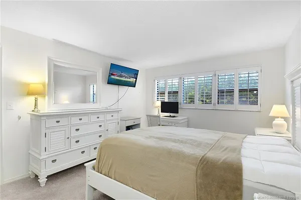 a bedroom with a bed a window and dresser