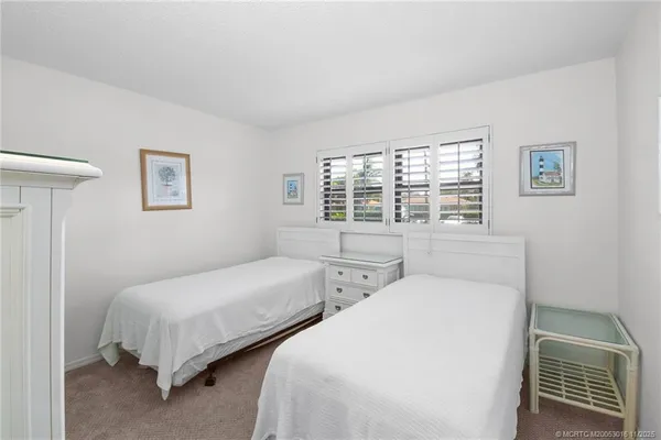 a bedroom with two beds and a window with outer view