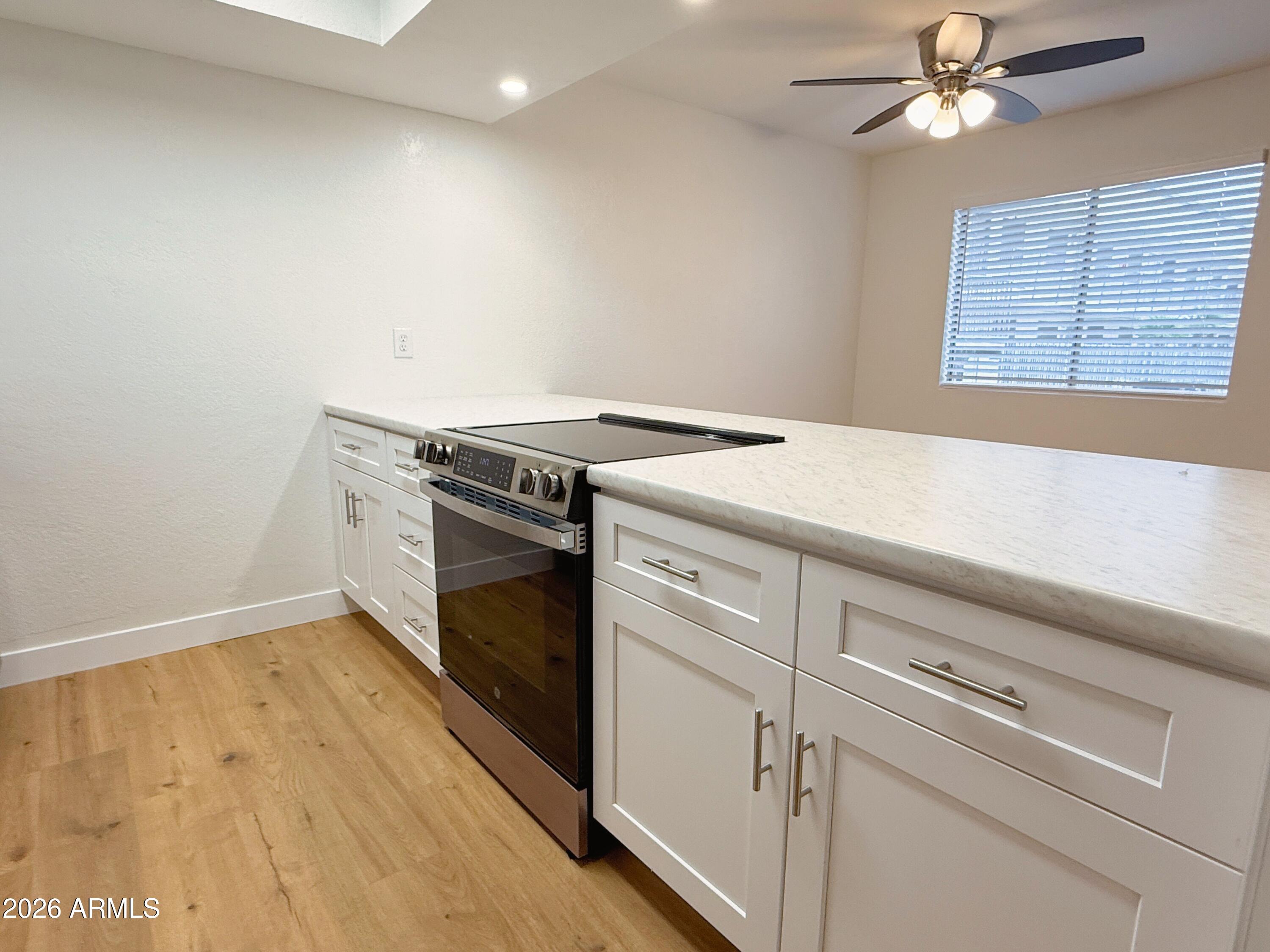 18202 North Cave Creek Road, Unit 148 Phoenix, AZ 85032 - Photo 7 of 19 a kitchen with a stove and a microwave