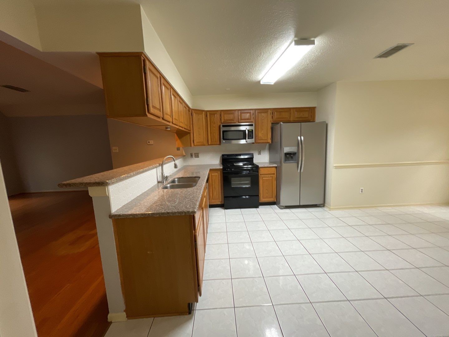 46 Sweetdream Place Spring, TX 77381 - Photo 14 of 18 a kitchen with stainless steel appliances kitchen island granite countertop a refrigerator and a stove