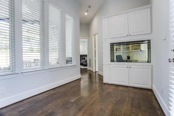 an empty room with wooden floor and cabinet
