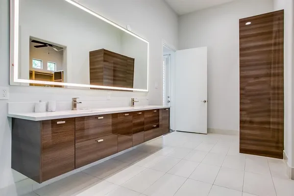 a spacious bathroom with a double vanity sink a mirror and a shower