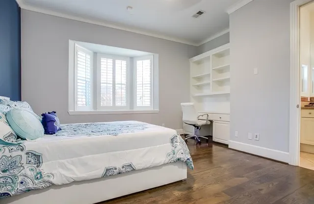 a bedroom with a bed wooden floor and a window
