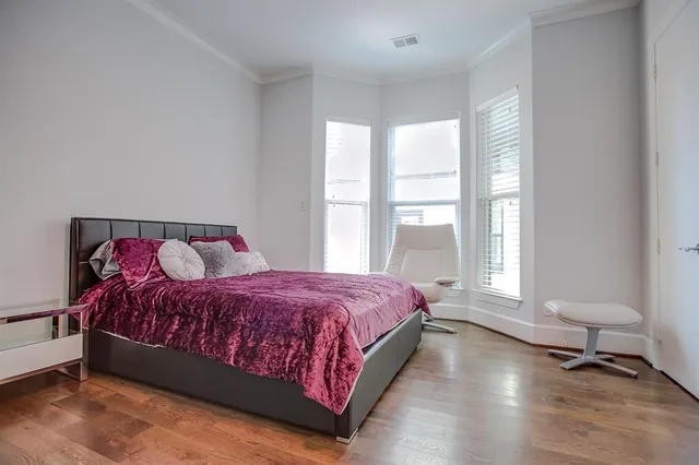 a spacious bedroom with a bed and a large window