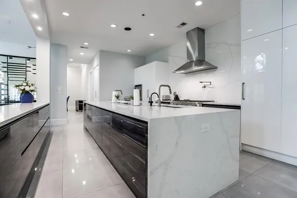 a large white kitchen with a large counter top appliances and cabinets