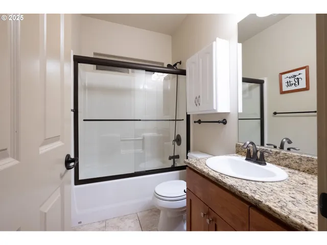 a kitchen with stainless steel appliances kitchen island granite countertop a refrigerator a sink a stove and oven with wooden floor