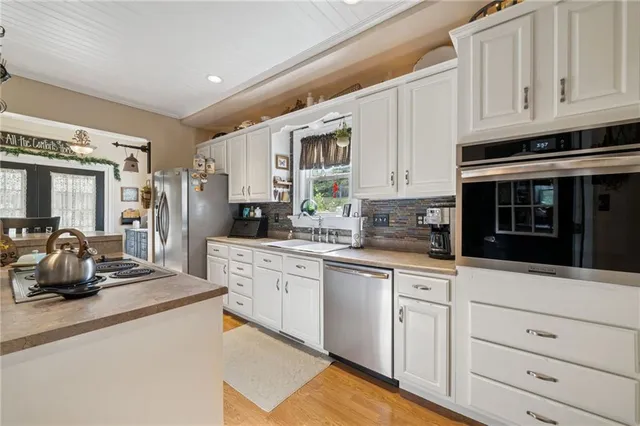 a kitchen with white cabinets and stainless steel appliances