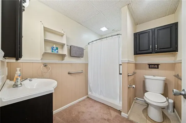 a bathroom with a sink a toilet and shower