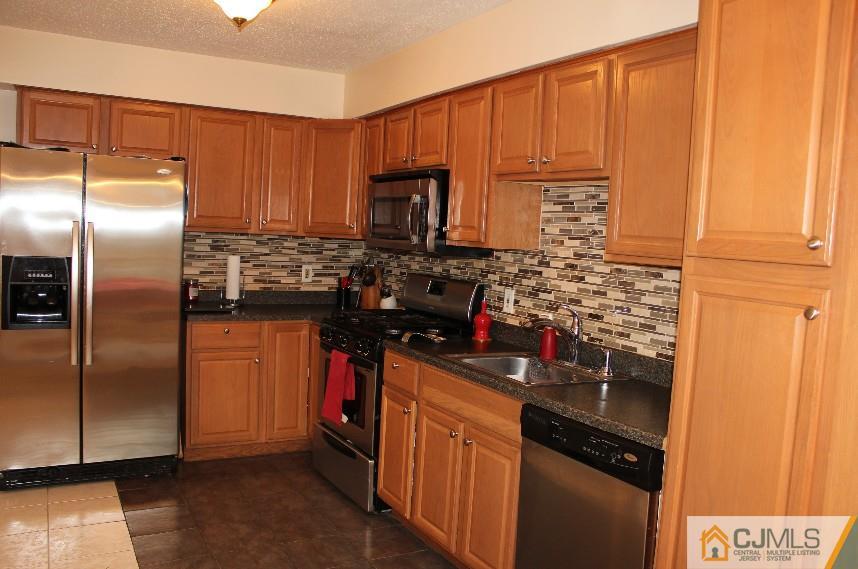 384 Draco Road Piscataway, NJ 08854 - Photo 2 of 19 a kitchen with stainless steel appliances a refrigerator and a stove