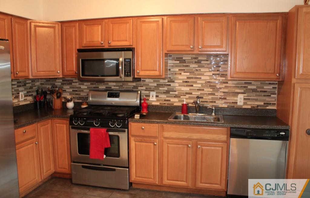 384 Draco Road Piscataway, NJ 08854 - Photo 3 of 19 a kitchen with stainless steel appliances a stove microwave and cabinets