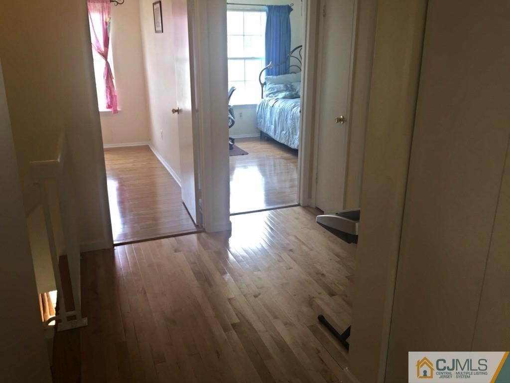 384 Draco Road Piscataway, NJ 08854 - Photo 9 of 19 a view of a hallway with wooden floor and a bedroom