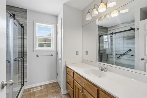 a bathroom with a sink vanity granite and a mirror