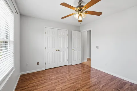 an empty room with wooden floor and windows