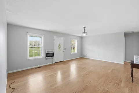 an empty room with windows and fireplace