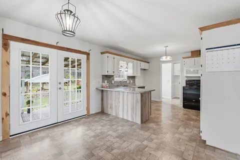 a kitchen with white cabinets and refrigerator