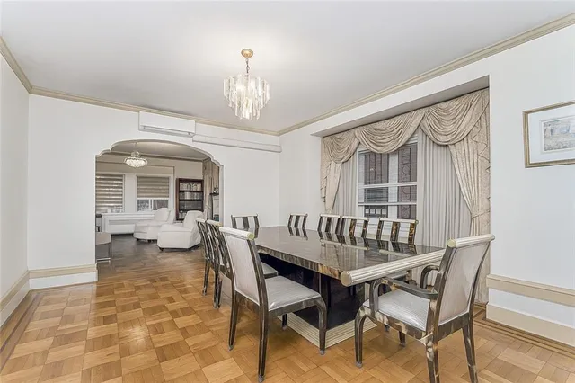 a dining room with furniture a chandelier and window