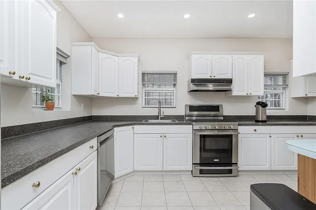 a kitchen with cabinets stainless steel appliances a sink and a stove