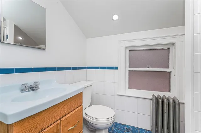 a bathroom with a granite countertop sink a toilet and a mirror