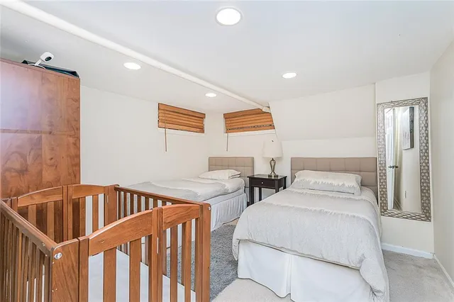 a bedroom with 2 bed and a window