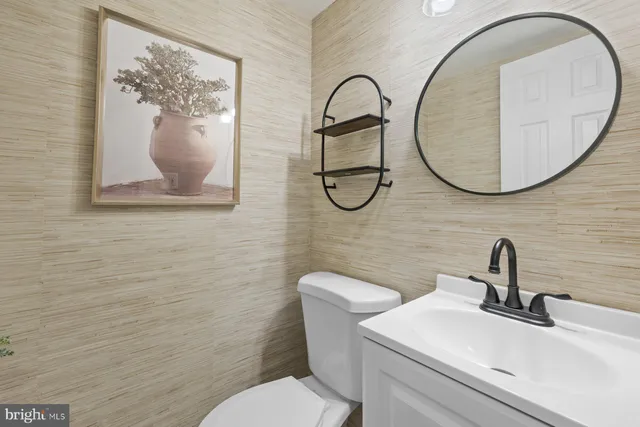 a bathroom with a toilet sink and mirror