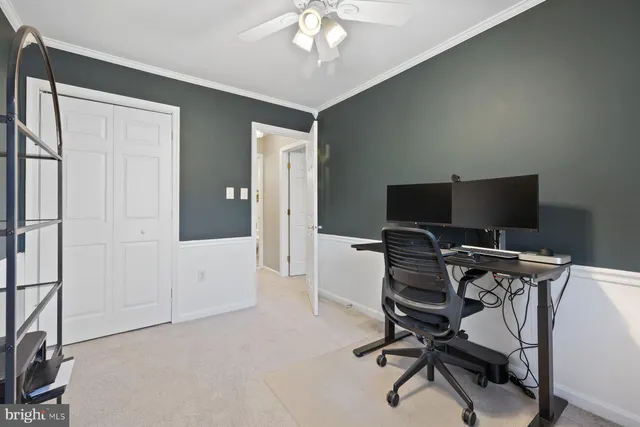 a view of a workspace with furniture and a ceiling fan