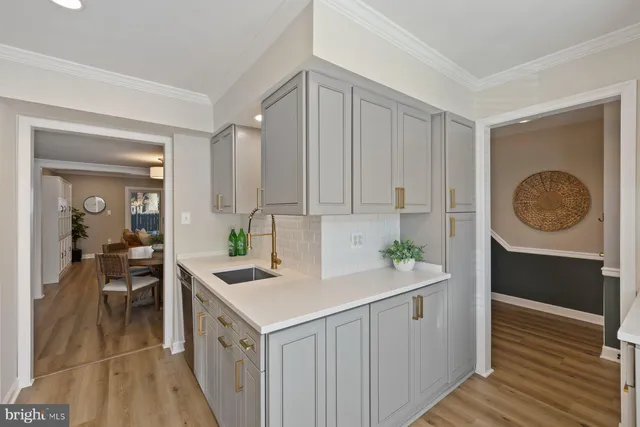 a kitchen with a sink cabinets and wooden floor