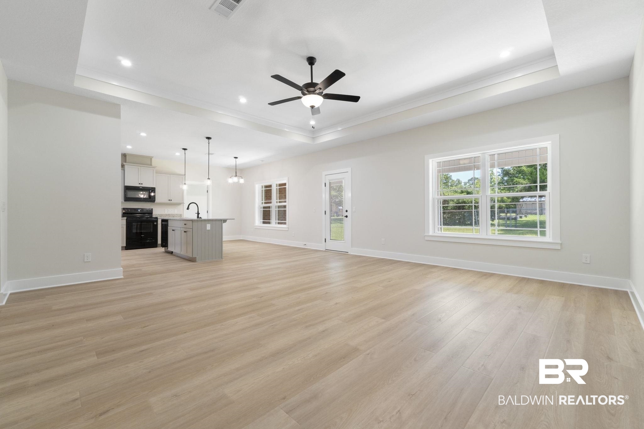 32563 Arbor Ridge Circle Lillian, AL 36549 - Photo 7 of 53 Unfurnished living room with a raised ceiling, light wood finished floors, a ceiling fan, recessed lighting, and crown molding