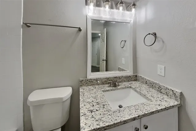 a bathroom with a sink and mirror with toilet