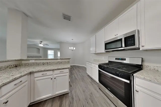 a kitchen with granite countertop a stove and a microwave oven