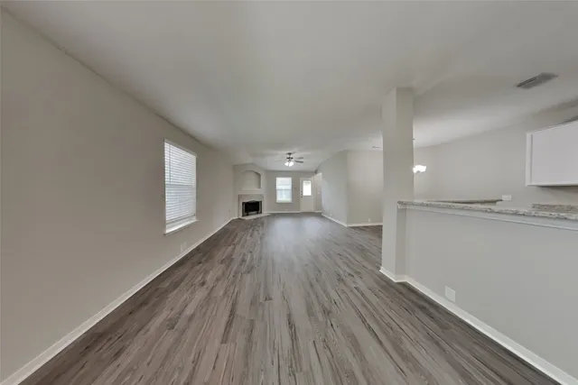 a view of empty room with wooden floor