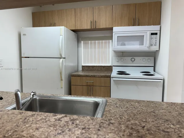a kitchen with a refrigerator and a sink