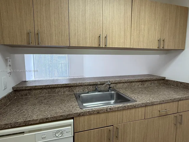 a kitchen with granite countertop white cabinets and sink