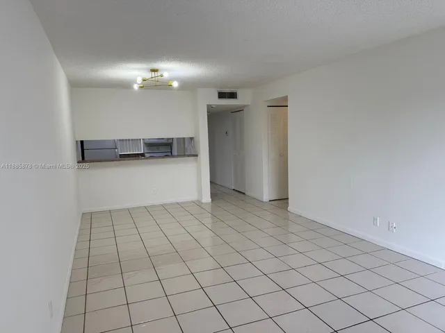 a view of a livingroom with an empty space and a window