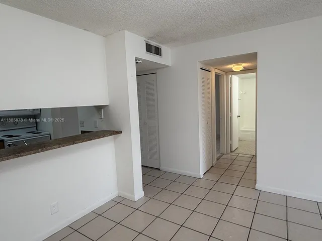 a view of kitchen with refrigerator and window