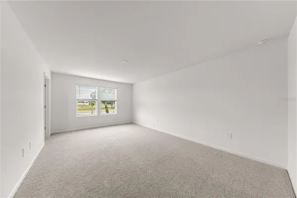 an empty room with windows and ceiling fan