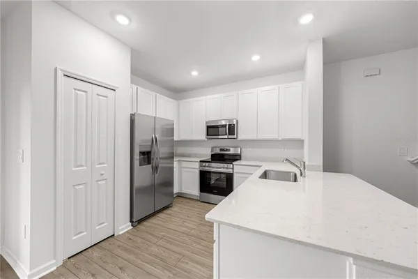 a kitchen with white cabinets and stainless steel appliances