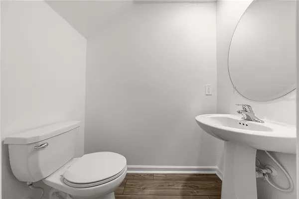 a bathroom with a toilet a sink and mirror