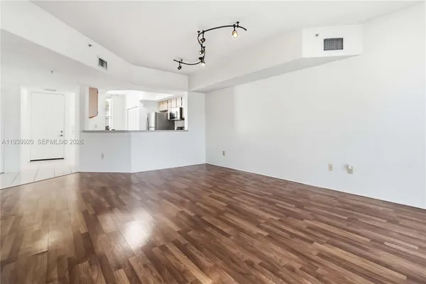 a view of a kitchen with wooden floor and cabinets