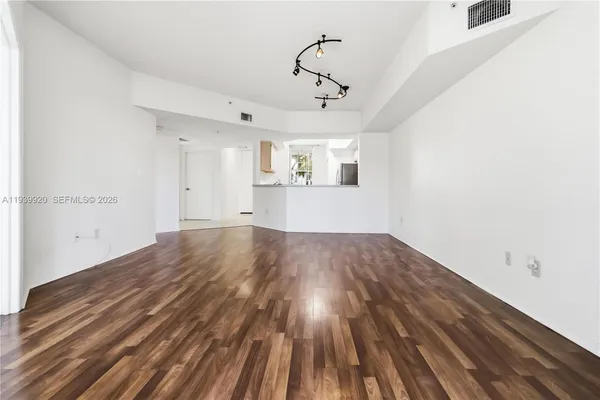 a view of empty room with wooden floor and ceiling fan