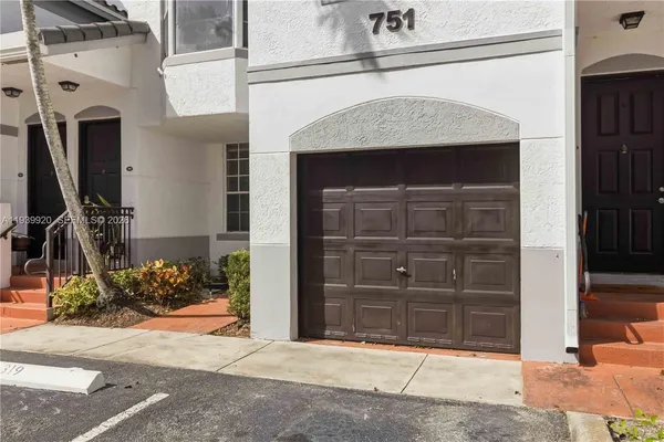 a view of front door and a car garage