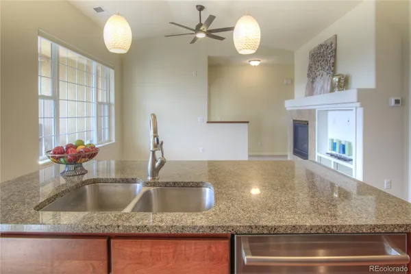 a kitchen with kitchen island a sink stainless steel appliances and a counter top space