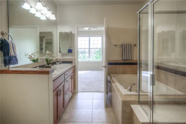 a bathroom with a granite countertop sink a toilet a mirror and bathtub