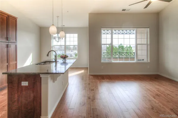 a kitchen with stainless steel appliances granite countertop wooden floors and sink