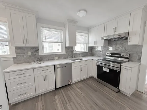 a kitchen with granite countertop white cabinets and white appliances