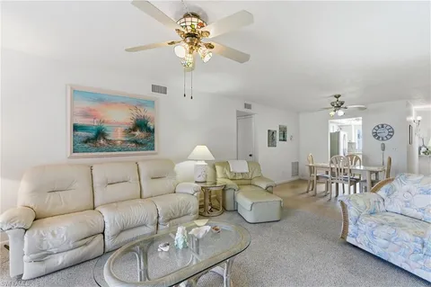 a living room with furniture a chandelier and a dining table