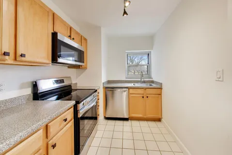 a kitchen with stainless steel appliances a stove microwave and sink