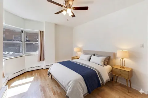 a bedroom with a bed and wooden floor