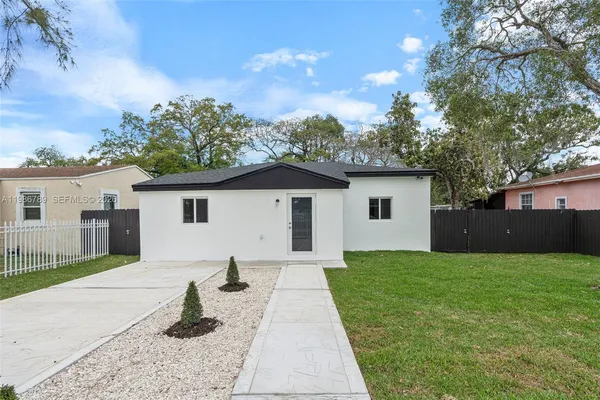 a view of a house with a yard and potted plants